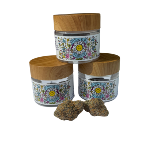 Three eco-friendly jars of Power Flower hemp with vibrant labels and two premium buds in front – available at HerbinLivingBotanicals.com.
